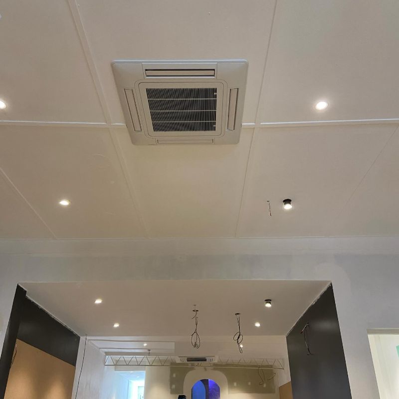 Ceiling cassette air conditioner in a commercial fit-out with downlights