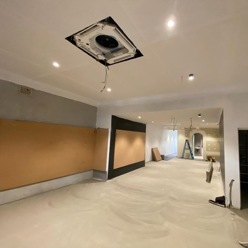 Ceiling cassette unit without its grille in a room still being fitted out