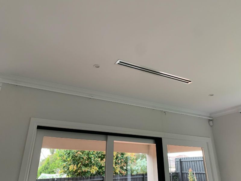 Ducted air conditioning slot vent in a ceiling above sliding doors