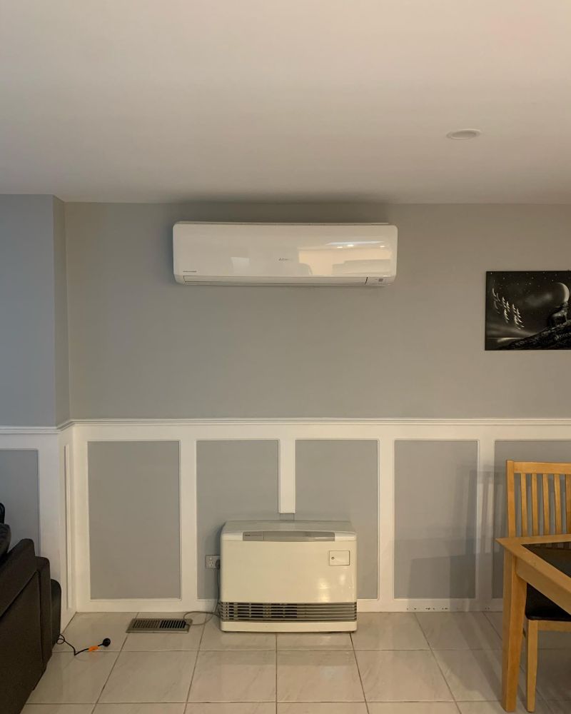 Split system air conditioner high on a living room wall