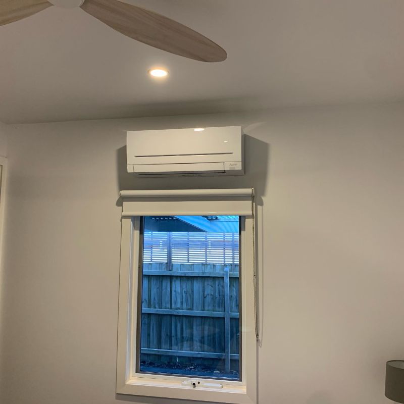 Split system air conditioner fitted above a small window