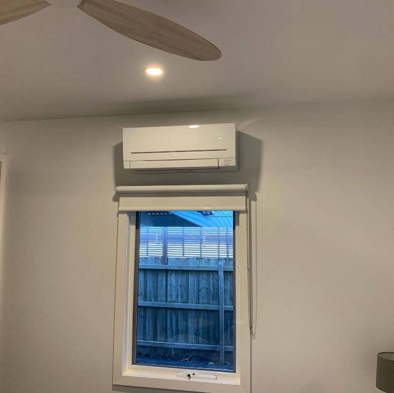 Split system air conditioner above a small window, closer view