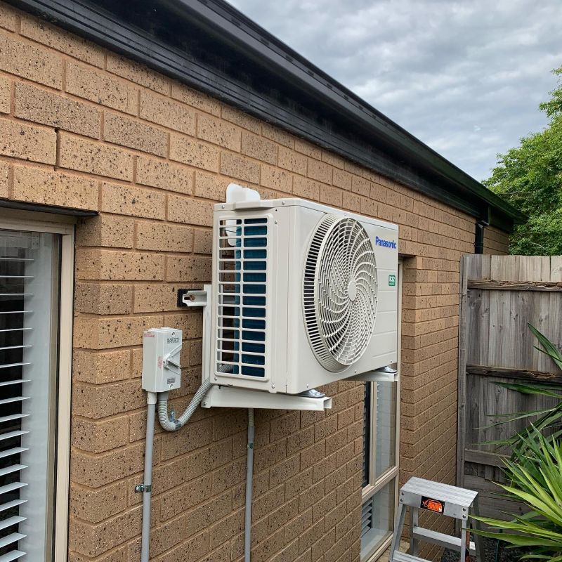 Panasonic outdoor unit on a wall bracket on a brick house