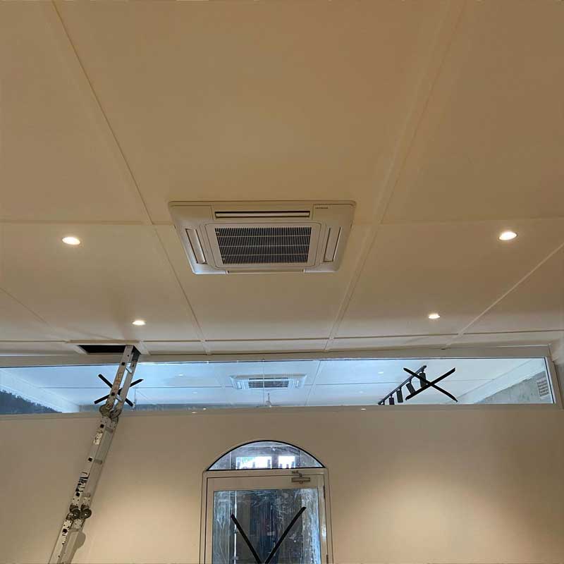 Ceiling cassette air conditioner in a room with downlights